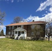 stort hus med tømmer laft synlig hvit terasse, gress