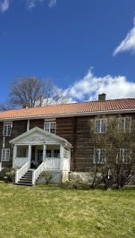 stort hus med tømmer laft synlig hvit terasse, gress