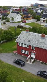 rødt trehus og kirke i droneperspektiv