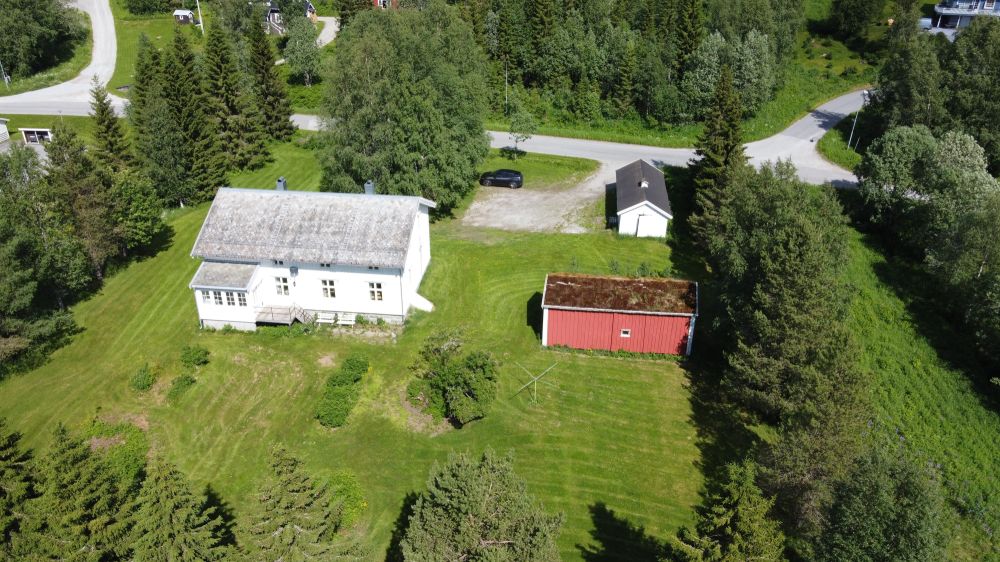 hvitt trehus og liten rød låve dronebilde