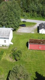 hvitt trehus og liten rød låve dronebilde