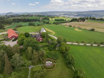 dronebilde av låve og jordarealer, hage