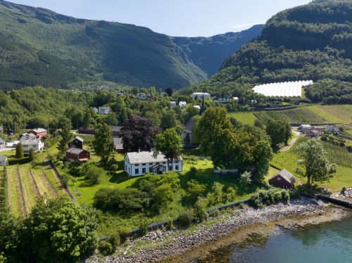 gammel gård med frukttrær i bakgrunn