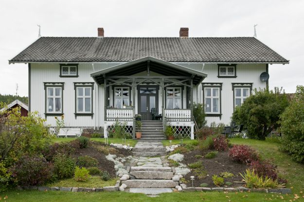 Gjerstad prestebolig. Hvitt trehus med grønne vinduskarmer og hage. Foto