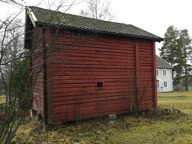 Rødt  stabbur i to etasjer på Våler prestegård