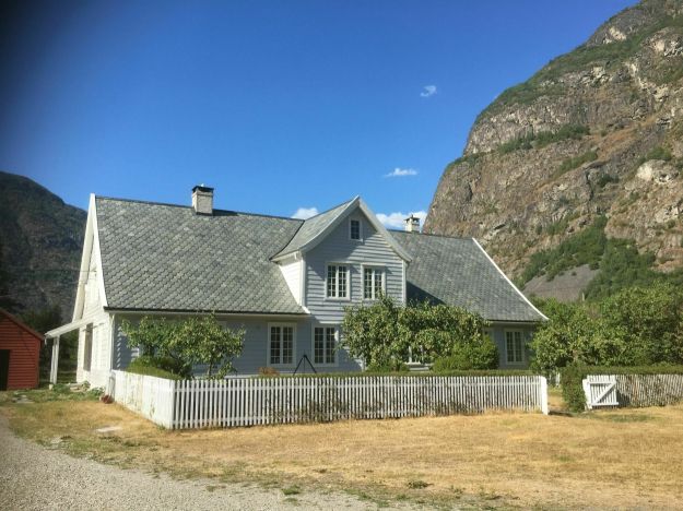 prestebolig med stakittgjerde og fjell i bakgrunn