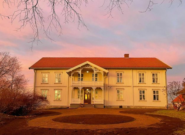 Sveitserhus med ettermiddagsglød på himmelen