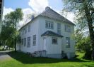 hvitt trehus, to etasjer, gressplen, skygge