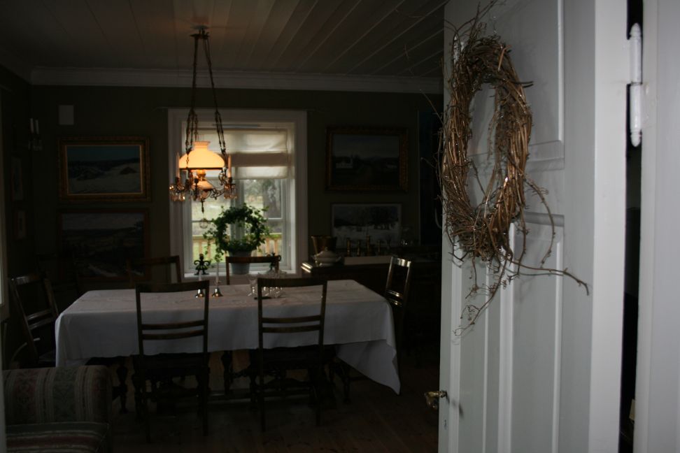 Stemningsbilde åpen dør og krans hengende på døra.