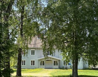 hvit husbygning på to etasjer i enden av alle