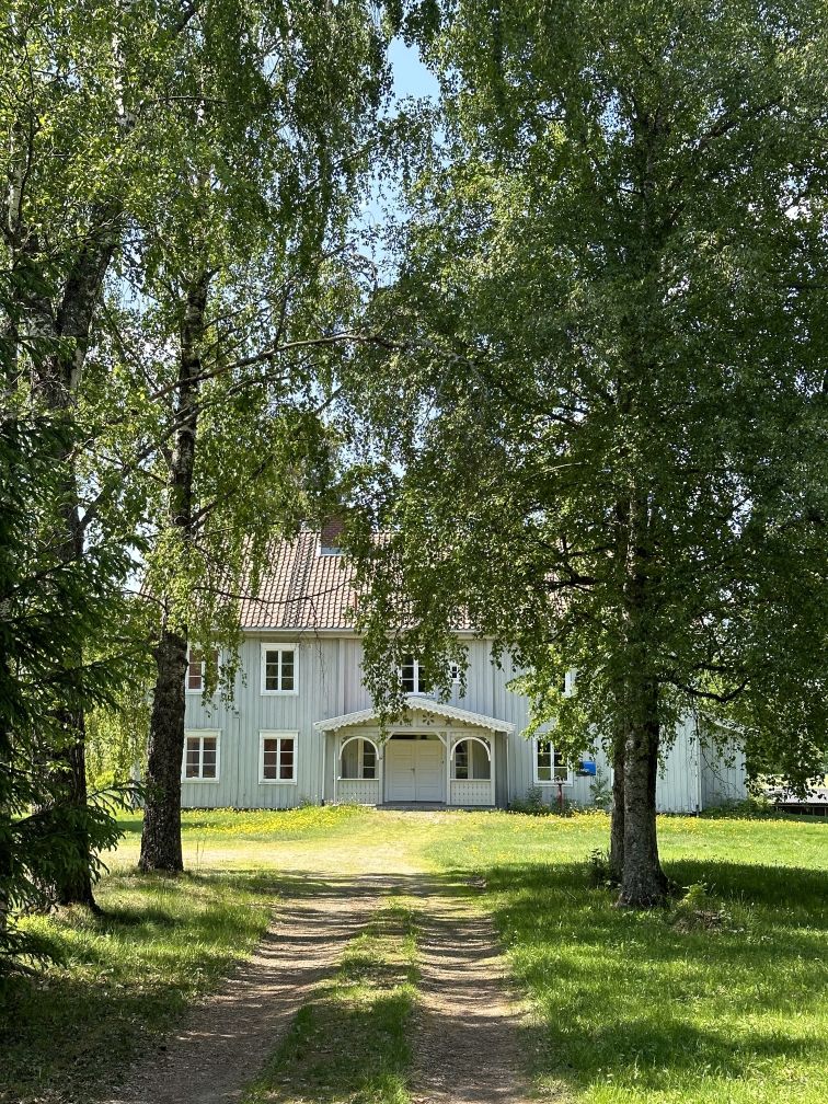 hvit husbygning på to etasjer i enden av alle