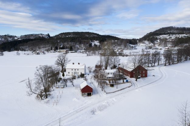 Dronebildet av gårdsbruk i vinterlandskap