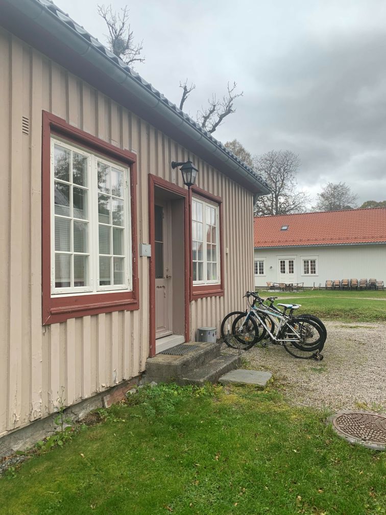 Hushjørne, gavl side med oppstilling plass for sykler og grønn plen