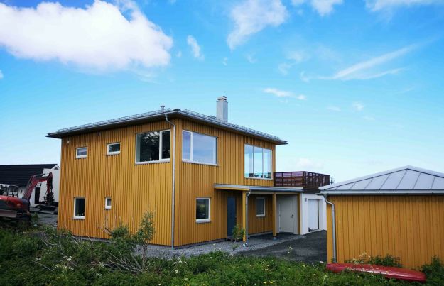 Gult trehus og åpen blå himmel