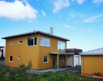 Gult trehus og åpen blå himmel