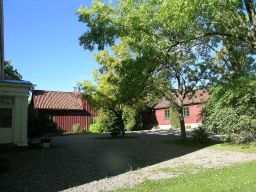 røde uthus med trær foran