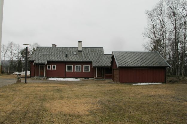 rød enebolig med snøklatt foran inngangen