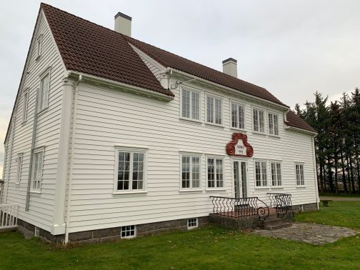 hvitt trehus med initialer i dørkarmen