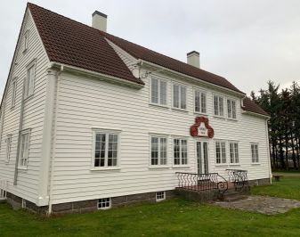 hvitt trehus med initialer i dørkarmen