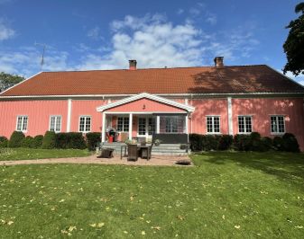 rødrosa lang trebygning med veranda