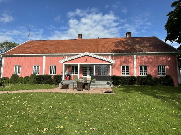 rødrosa lang trebygning med veranda