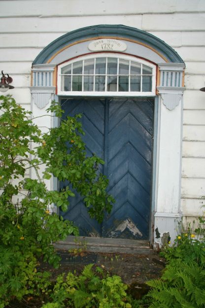 dørinngang, bue og monogram over.