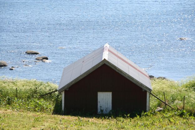 rødt trehus, sjø, gress