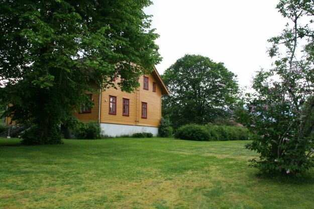 gress med okergul gavl side på hus