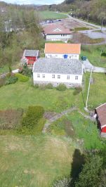 Dronebilde, hus og uthus vei og skog