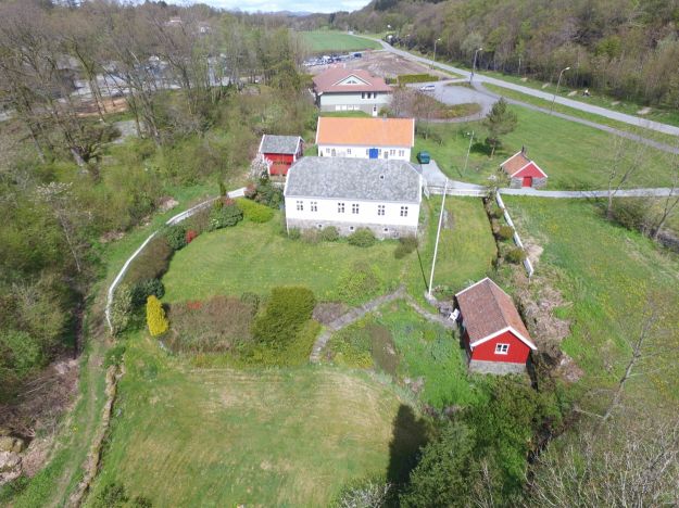 Dronebilde, hus og uthus vei og skog