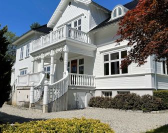 Storslått hvitmalt trehus i herregårdsstil