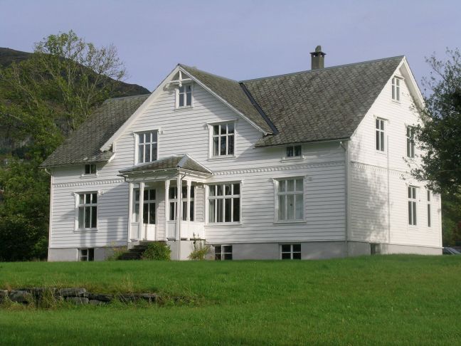 Hvitmalt flott trehus med hagen i forkant