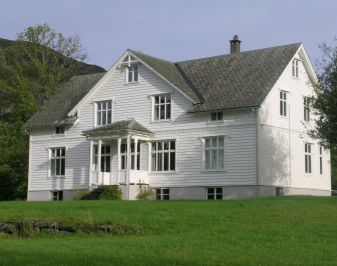 Hvitmalt flott trehus med hagen i forkant