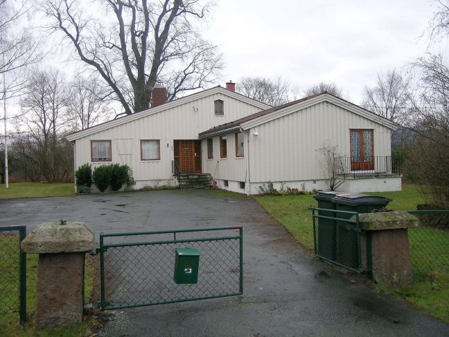 Nyere bolig med innkjørsel og tun i forgrunnen