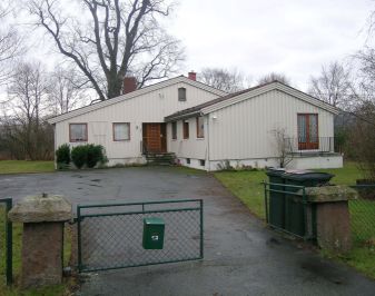 Nyere bolig med innkjørsel og tun i forgrunnen