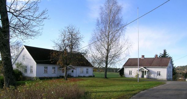 Hvit hovedbygning i tre med tuntre