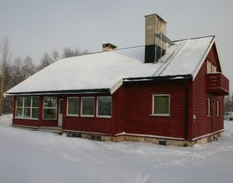 Nyere rødmalt trebygning ved kirken