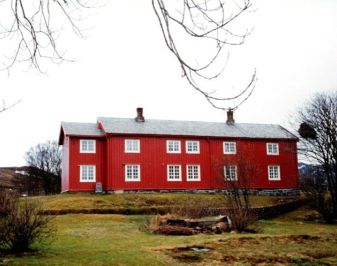 Fredet rødmalt tømmerbygg fra tidlig attenhundretall