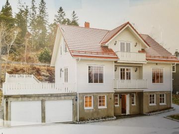 To etasjes bolig med høy grunnmur i Rissa med ark, hvitmalt