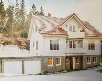 To etasjes bolig med høy grunnmur i Rissa med ark, hvitmalt