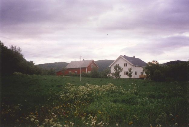 Hvitmalt våningshus med gårdstun