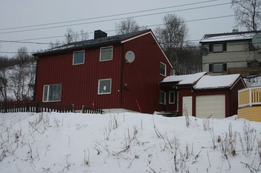 Nyere rødt trehus i vinterlandskap