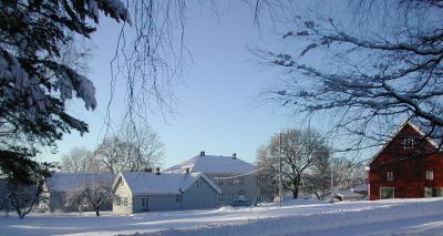 Storgård med flere bygninger. Vinterbilde