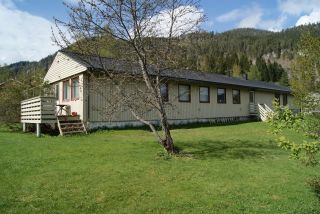 Nyere enebolig i tre med gressplen i forkant