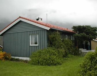 Nyere prestebolig sett fra gavl siden med tåke på baksiden