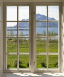 fjelltopp som man ser ut på gjennom et småsprosset vindu.