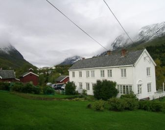 Hvit hovedbygning i tre bygd rett etter krigen.