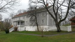 Lyst trehus med grønn hage foran