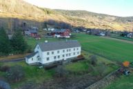 Øyer prestegård en to etasjes meget lang trebygning i en helling i landskapet